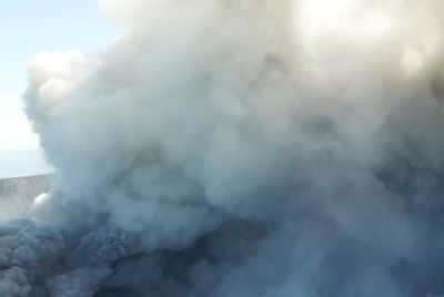 Smoke emitting from volcanic mountain against sky