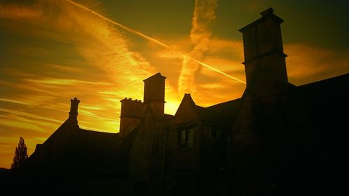 High section of silhouette built structures against sunset