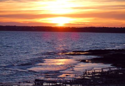 Scenic view of sea against romantic sky at sunset