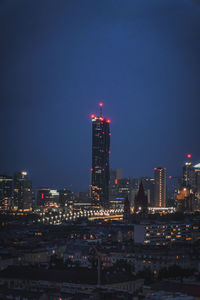 Illuminated cityscape against sky at night