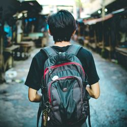 Rear view of man walking on street in city