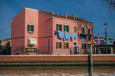 Building by river against sky