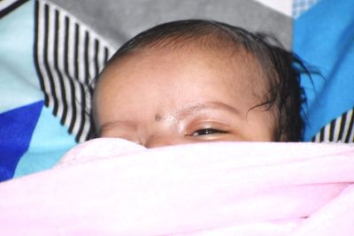 Portrait of cute baby girl in bed