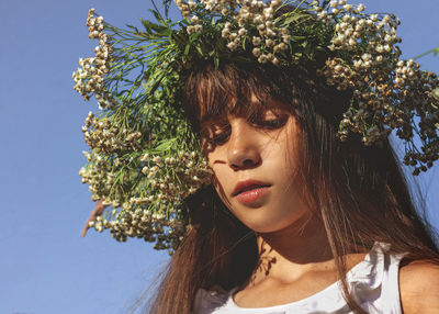 Close-up portrait of young woman against tree