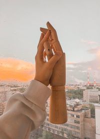 Midsection of person holding camera against sky