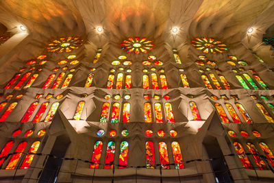 Low angle view of illuminated lights hanging from ceiling in temple