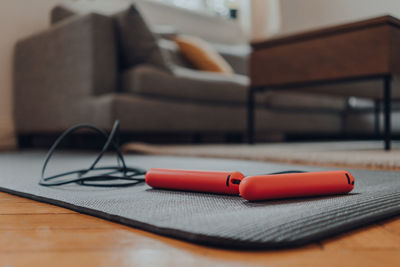 Close up of a jump rope on top of a fitness mat on a floor, modern interior, selective focus.