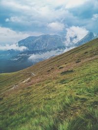 Scenic view of mountains against cloudy sky