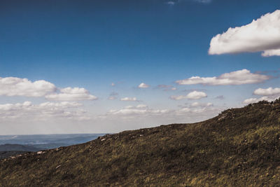 Scenic view of sea and mountains against blue sky