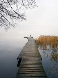 Pier over lake against sky during winter