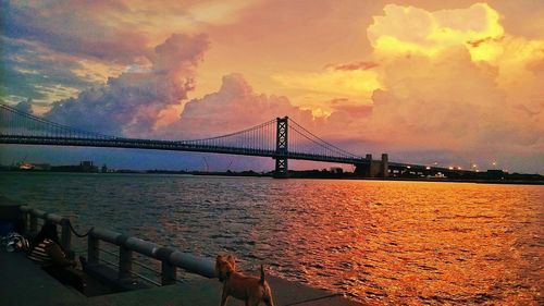 Bridge over river at sunset