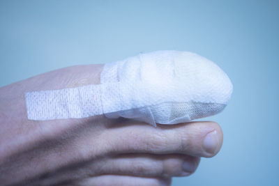 Close-up of human hand against blue background