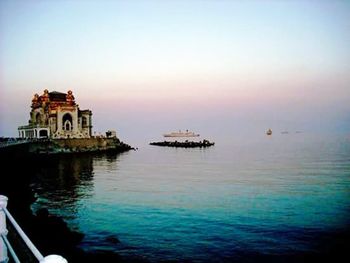 Boats in sea at sunset