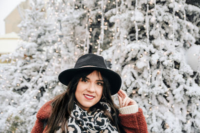 Portrait of smiling woman against christmas tree