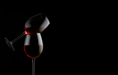 Low angle view of wine glass against black background