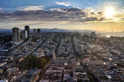 Aerial view of city against cloudy sky