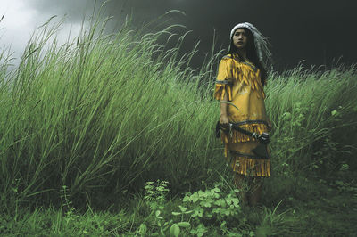 Young woman standing on field against sky at night