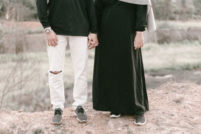 Low section of man and woman standing on land