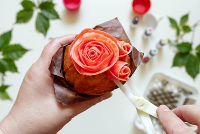Cropped hands icing cupcake at home