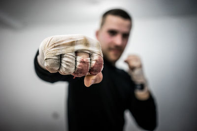 Close-up of male athlete showing fists with hand wrap