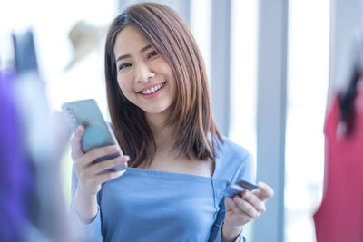 Smiling young woman using mobile phone