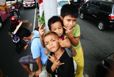 High angle portrait of friends standing by car