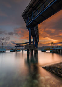 Pier over sea against sky during sunset