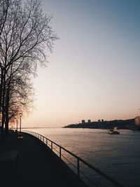 Scenic view of river against clear sky at sunset