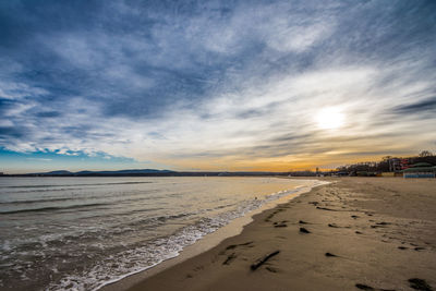 Scenic view of beach against sky during sunset