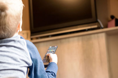 Rear view of man using mobile phone