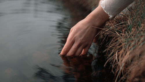 Cropped hand of woman in water