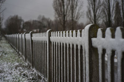 Fence on snow covered landscape