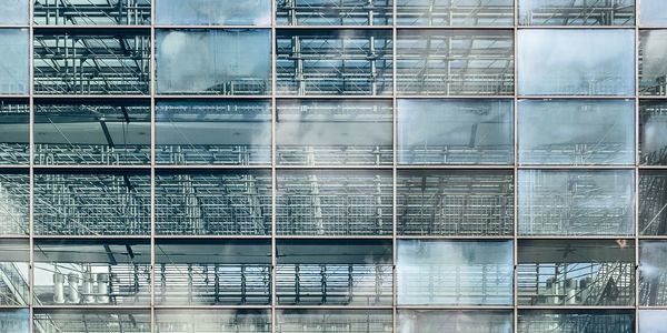 Low angle view of glass building against sky