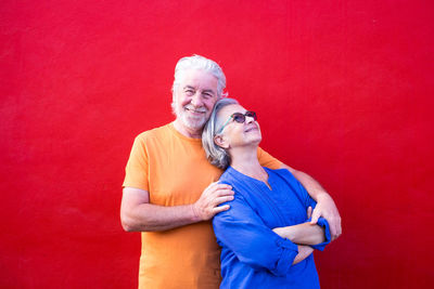 Portrait of a smiling young man against red background
