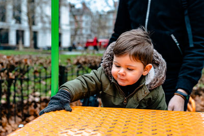 Smiling boy playing at playground during winter