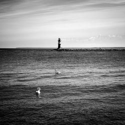 Lighthouse on sea against sky