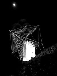 Low angle view of illuminated spider web against sky at night