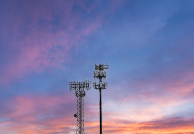 Low angle view of communications tower against sky during sunset