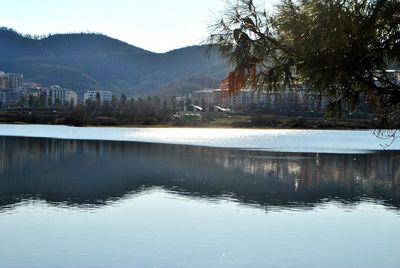 Scenic view of lake by mountains against sky