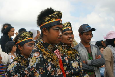 Group of people in traditional clothing against sky