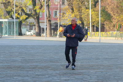 Rear view of man walking on street.