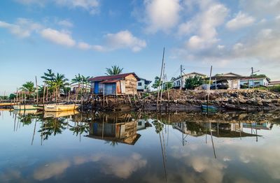 Houses by lake against sky