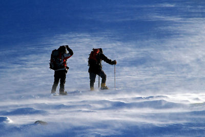 Rear view of hikers on snowcapped landscape