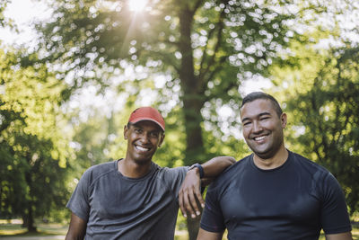Portrait of smiling male friends after working out at park