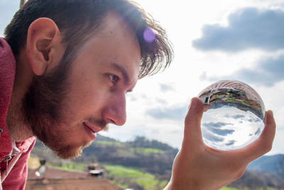 Close-up of young man holding crystal ball