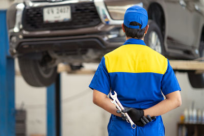 Rear view of mechanic working in autorepair shop