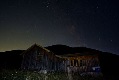 Abandoned house on field against sky at night