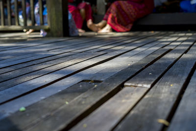 Close-up of wooden bench on footpath