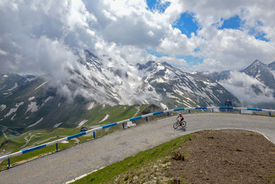 High angle view of person riding bicycle on road by mountains against sky