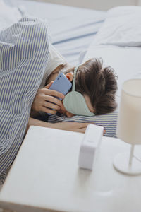 Rear view of woman using mobile phone on table